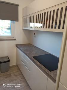 a kitchen with white cabinets and a counter top at Villa Luna in Biograd na Moru