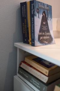 a stack of books sitting on a shelf at Studio Cozy - In the Heart of Skyros Village in Skiros