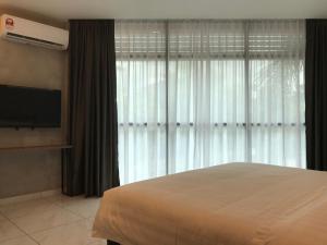 a bedroom with a bed and a large window at Tekoma Hotel Ipoh - Dandelion Inn in Simpang Pulai