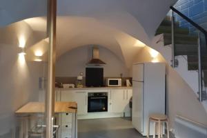 a kitchen with a white refrigerator and a table at Maison de bourg in Vic-le-Comte