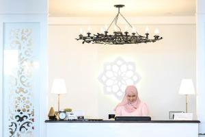 a woman sitting at a desk with a laptop at Noursabah Pattaya in Pattaya Central