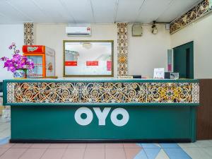 a oco counter in a store with a sign on it at Super OYO 1018 Telang Usan Hotel Miri in Miri