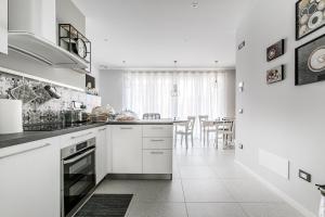 a kitchen with white cabinets and a dining room at B&B Il Granaio Celeste in Porto Viro