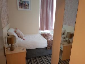 a small bedroom with a bed and a window at 74 Belgravia in Torquay