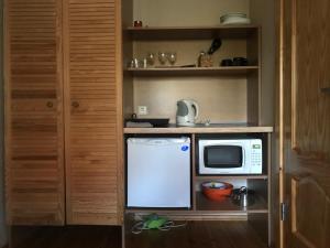 a small kitchen with a microwave and a refrigerator at Vila Mares in Palanga