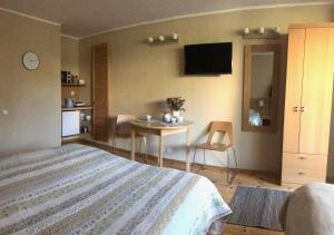 a bedroom with a bed and a table and a tv at Vila Mares in Palanga