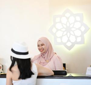 a woman sitting at a counter in a hair salon at Noursabah Pattaya in Pattaya Central