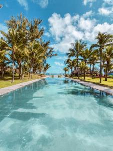 a swimming pool filled with lots of blue water at Outrigger Mauritius Beach Resort in Bel Ombre