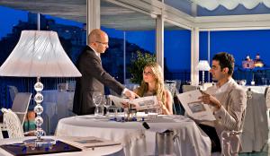 a group of people standing around a table in a restaurant at Miramare E Castello in Ischia