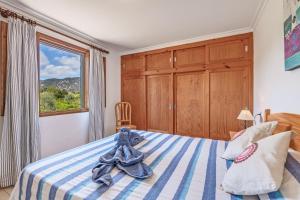 a bedroom with a blue and white bed with a window at Ca n Tres Cames Cuxach de n Joan in Pollença +17 photos