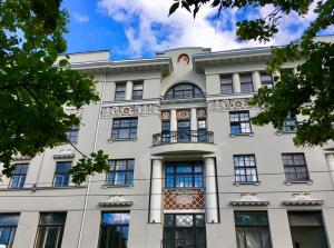 - un grand bâtiment blanc avec des fenêtres bleues dans l'établissement Centrally located apartment overlooking Vermanes Park, à Riga