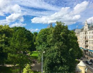 - une vue sur un parc arboré et des bâtiments dans l'établissement Centrally located apartment overlooking Vermanes Park, à Riga