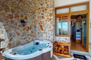 a bath tub in a room with a stone wall at Limeri Traditional Guest House in Monólithos