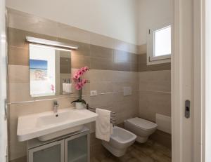 a bathroom with a sink and a toilet at Coru e Mari - City Center & Private Parking in Pula