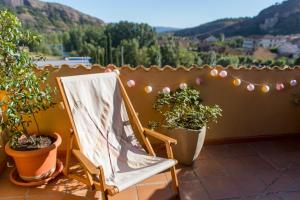una silla sentada en un balcón con macetas en Ático con terraza en Graus-Pirineo de Huesca, en Graus