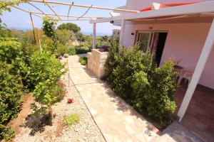 a garden outside a house with bushes and a patio at Chiaro di Luna in Santa Domenica
