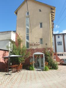 a building with tables and umbrellas in front of it at Pensiunea Vila Dana in Cluj-Napoca
