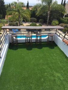 un patio con mesa y taburetes junto a una piscina en Villa Anna Maria, en Bahía de Coral