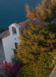 a small white building with a window next to the water at Studio Cozy - In the Heart of Skyros Village in Skiros