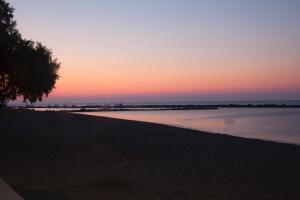 a sunset over a body of water with a tree at Studio Cozy - In the Heart of Skyros Village in Skiros