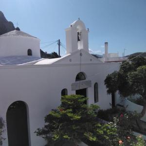 a white church with a tree in front of it at Studio Cozy - In the Heart of Skyros Village in Skiros