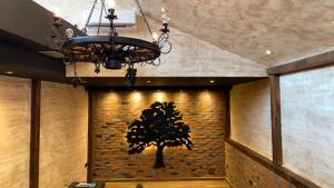 a chandelier and a tree on a brick wall at Motel Stari Hrast in Markovac