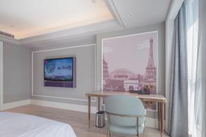 um quarto com uma secretária com uma cadeira e uma janela em Mercure Hotel Hangzhou East Railway Station em Hangzhou