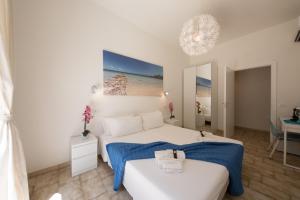 a white bedroom with a bed and a mirror at Coru e Mari - City Center & Private Parking in Pula
