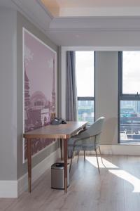 a dining room with a wooden table and two chairs at Mercure Hotel Hangzhou East Railway Station in Hangzhou