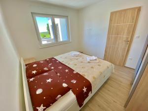 małą sypialnię z łóżkiem z brązowym kocem w obiekcie NOEL - three bedroom apartment with pool w mieście Banjole +37 zdjęć