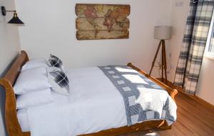 1 dormitorio con 1 cama con sábanas y almohadas blancas en Bluebell Cottage at The Old Tractor Barn en Brackley