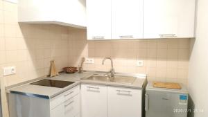 una cocina con armarios blancos y fregadero en 16 Casa Azul en Alfarim
