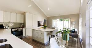 eine Küche mit weißen Schränken und einer weißen Arbeitsplatte in der Unterkunft The Rose Cottage in Kapstadt