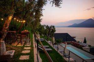 a patio with a table and a view of the water at Sunset Residence in Brenzone sul Garda