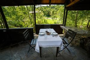 einen Tisch mit einem weißen Tischtuch auf einer Terrasse in der Unterkunft Casa Poveste Pensiunea-Muzeu in Câmpulung Moldovenesc