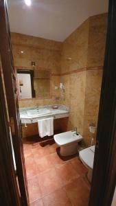 a bathroom with two sinks and a toilet and a mirror at Coso Viejo in Antequera