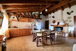 - une cuisine avec des placards en bois, une table et des chaises dans l'établissement Domo mea, à Porto Torres