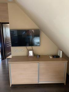 een tv op een dressoir in een kamer bij Robinson szigete in Balatonfüred