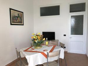 a dining room table with a vase of flowers on it at La Casa Sulla Scogliera in Cefalù