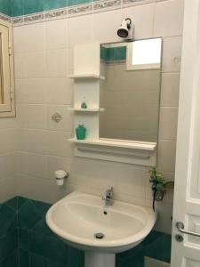a bathroom with a sink and a mirror at La Casa Sulla Scogliera in Cefalù