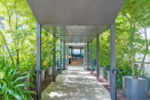 an office corridor with trees and a walkway at L'Agapa Hôtel - Spa Codage in Perros-Guirec