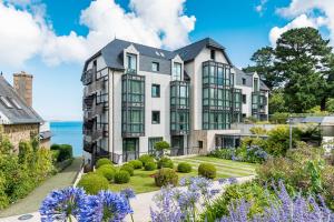 an exterior view of a large house with a garden at L'Agapa Hôtel - Spa Codage in Perros-Guirec