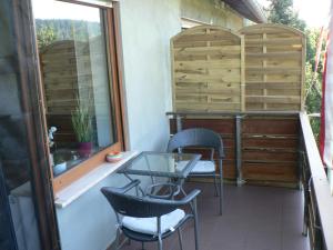 een balkon met stoelen, een tafel en een raam bij Brands Appartement in Ober-Nauses