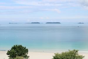 a view of the ocean with islands in the distance at L'Agapa Hôtel - Spa Codage in Perros-Guirec