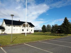 a large white building with a flag pole in a parking lot at Hannuksen Piilopirtti in Tyrnävä +2 photos
