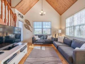 ein Wohnzimmer mit einem Sofa und einem TV in der Unterkunft The Golf & Mountain View Retreat by Instant Suites in Mont-Tremblant