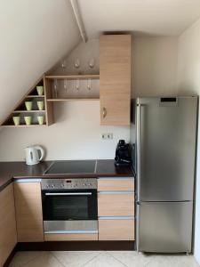 a kitchen with a stainless steel refrigerator and wooden cabinets at Robinson szigete in Balatonfüred