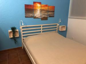 ein Schlafzimmer mit einem Bett mit drei Gemälden an der Wand in der Unterkunft Studio - Praia da Falesia - Algarve in Albufeira