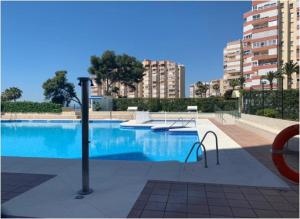 une grande piscine bleue avec des bâtiments en arrière-plan dans l'établissement SPECTACULAR VIEWS PENTHOUSE IN 1ST LINE BEACH, à Torrox Costa