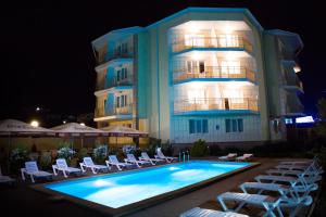 un hotel con piscina frente a un edificio en Tchernomorye Resort, en Nébug